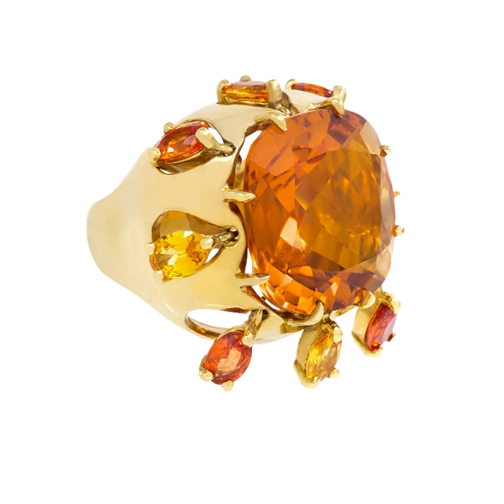 A gold ring with a large orange stone
